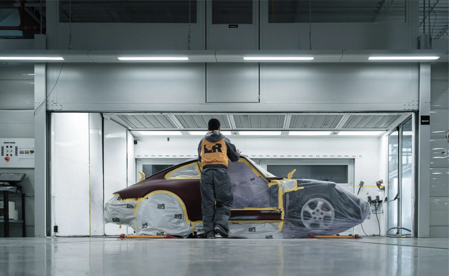Vehicle masked and prepped inside a downdraft paint booth